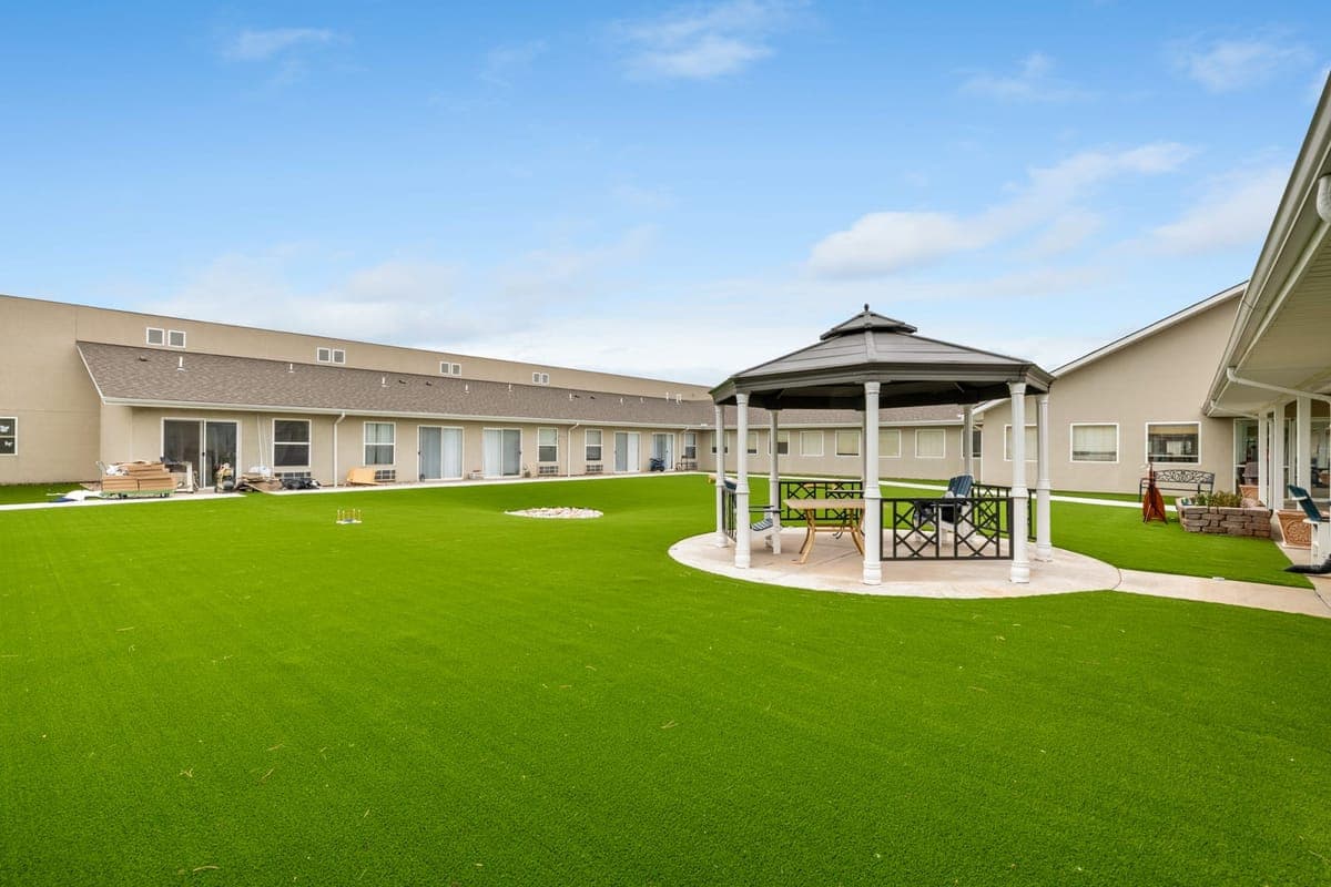 BelVilla’s central courtyard with a shaded gazebo and open green lawn.
